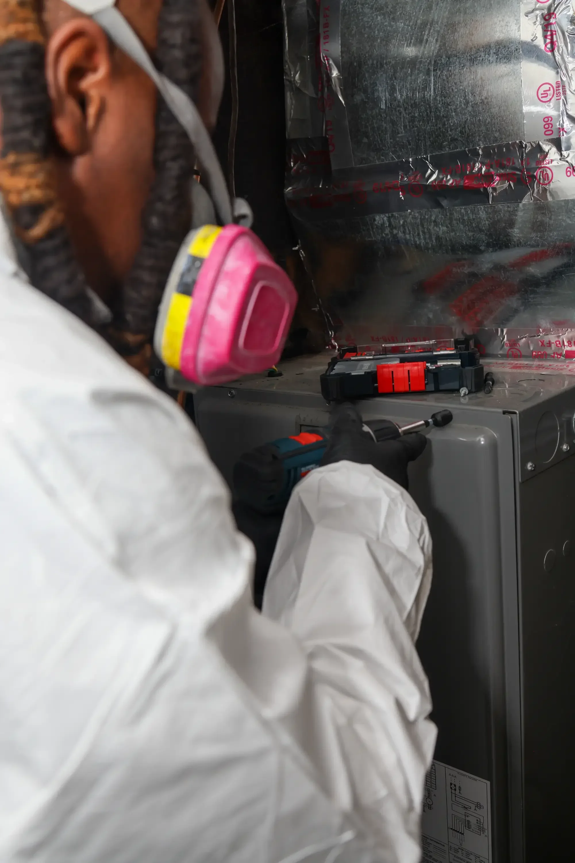 Inspector in protective gear collecting mold samples with specialized testing equipment